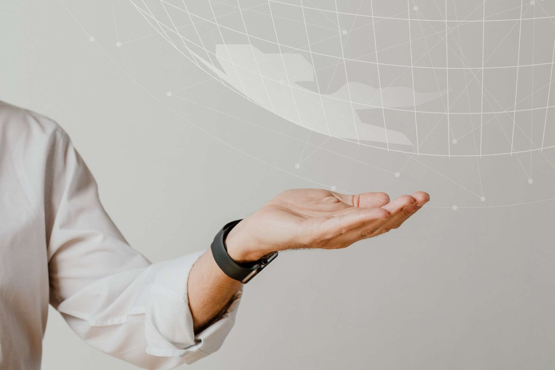 Male left hand holding a hologram of Earth, representing digital solutions services.